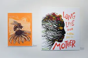 2 prints of artwork on a white gallery wall.